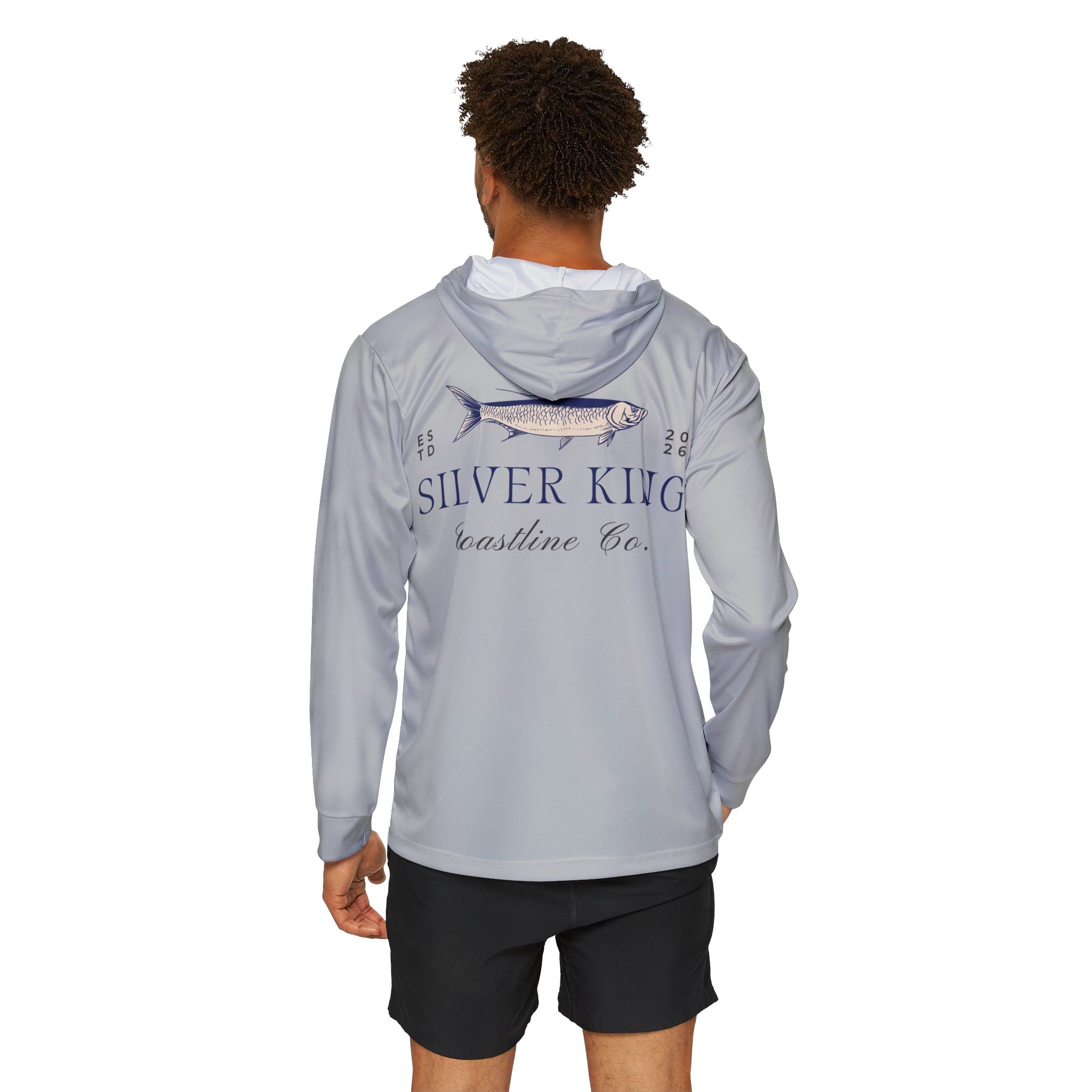 A man viewed from the back wearing a light gray hooded long-sleeve shirt with a large fish graphic and the text 'SILVER KING Coastline Co.' printed on the back, paired with black shorts against a plain white background.
